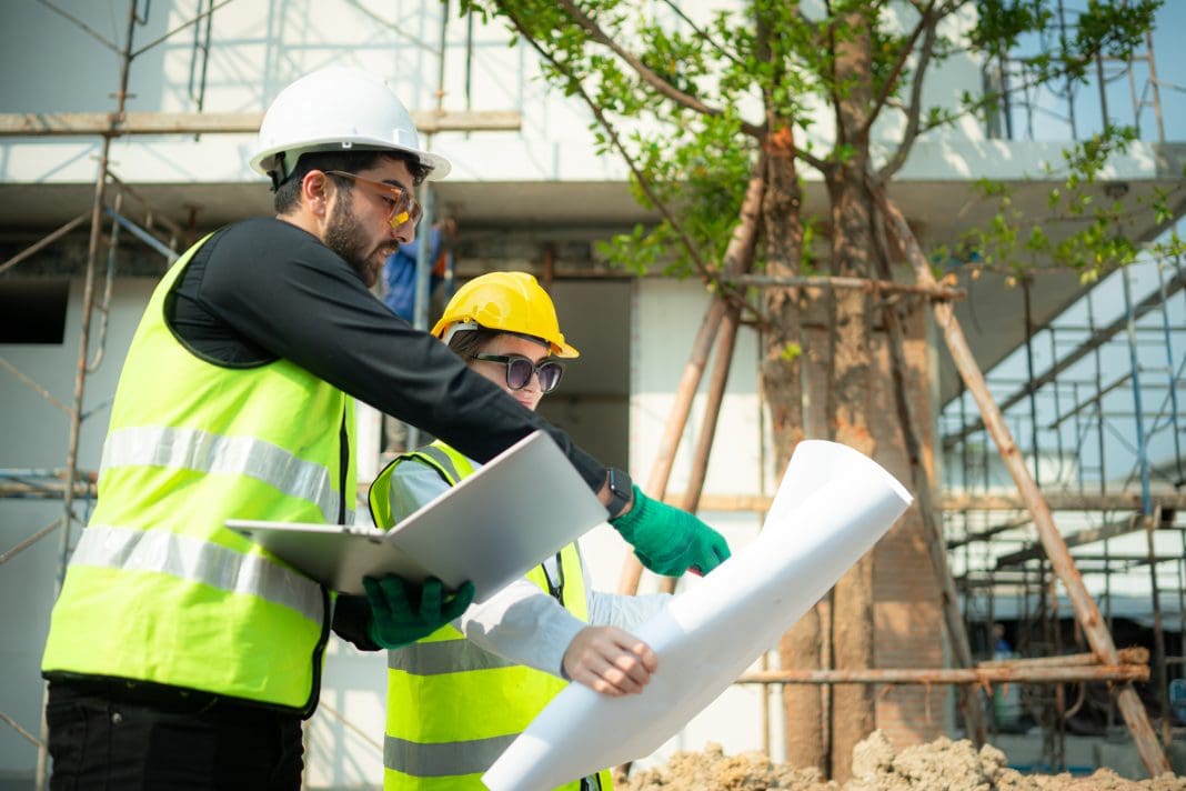 Construction workers consulting documents, as Amanda Lewis discusses the construction green skills shortage