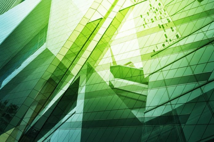 An abstract image of modern glass buildings in green light representing #GreenSkillsAtCOP