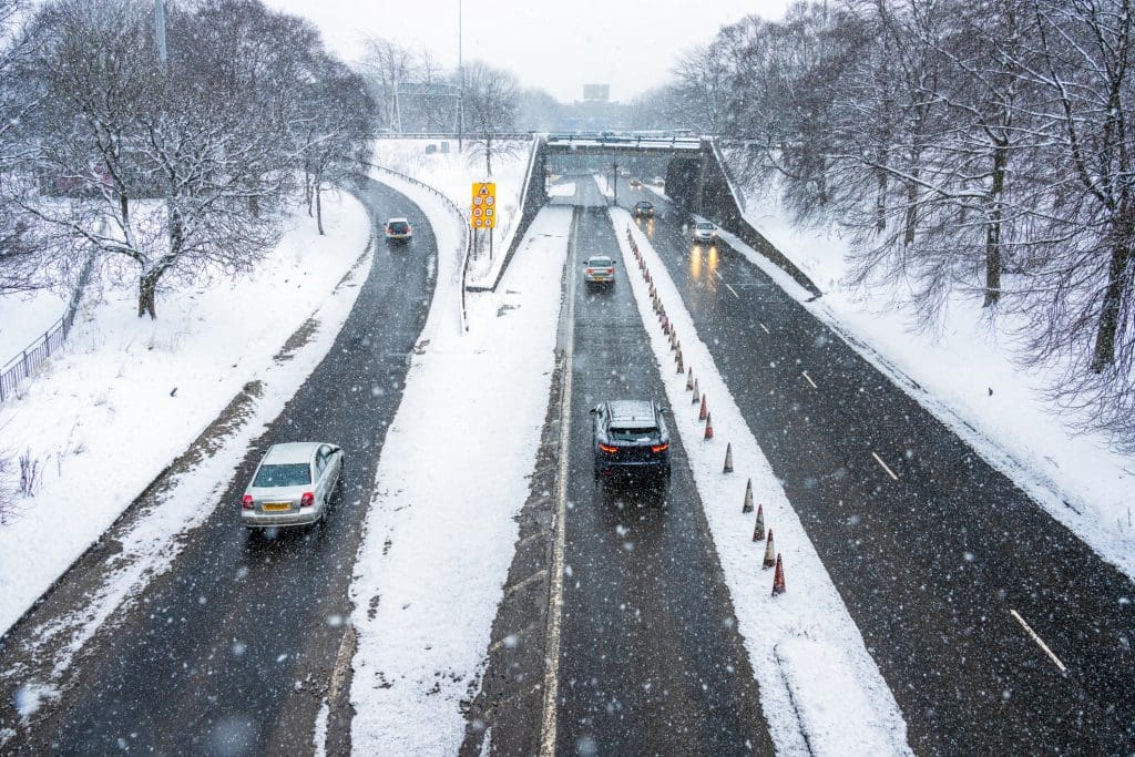 Traffic during heavy snow in Glasgow, Scotland, with cars heading towards the Clyde Tunnel.