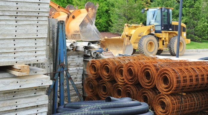 Various piles of building materials (concrete, tubing, wire) at a construction site.