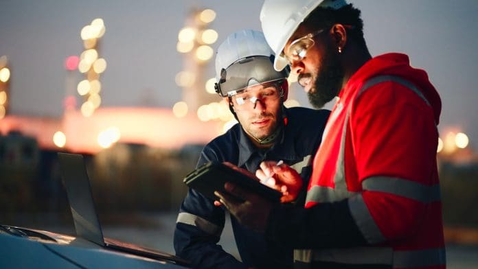 Team Inspection engineers working with laptop of oil factory and gas refinery plant industry at night for inspector safety quality control, representing the need for mobile field worker solutions