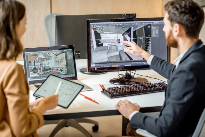 Two creative office employees making interior design on the computer and digital tablet at the modern office of architectural firm. Concept of 3d modelling and digital Interior designing, representing sustainability data