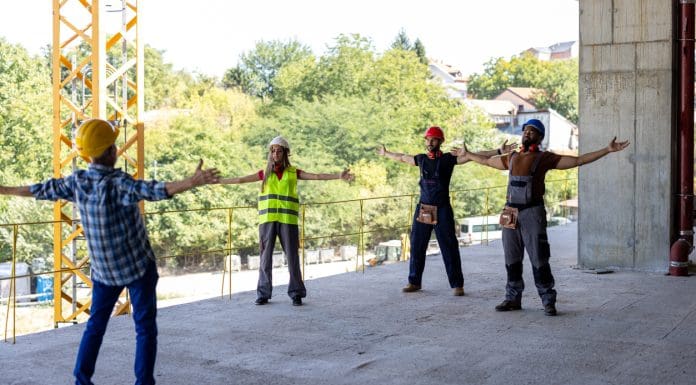 A Multi-Ethnic Group of Construction Workers are Doing Some Morning Exercises at the Construction Site, representing CITB's Consensus